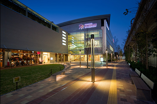 プロムナードに面して芝生広場を囲んだスポーツクラブ商業施設　経堂スポールクラブビル夜景