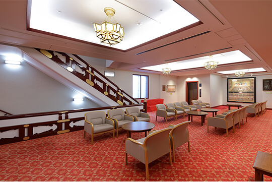 2階ロビーの再生された照明器具と階段高欄飾り金物 ©(株)エスエス