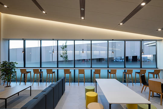 勾配天井が特徴的なラウンジからスロープを望む ©株式会社伸和／木原慎二